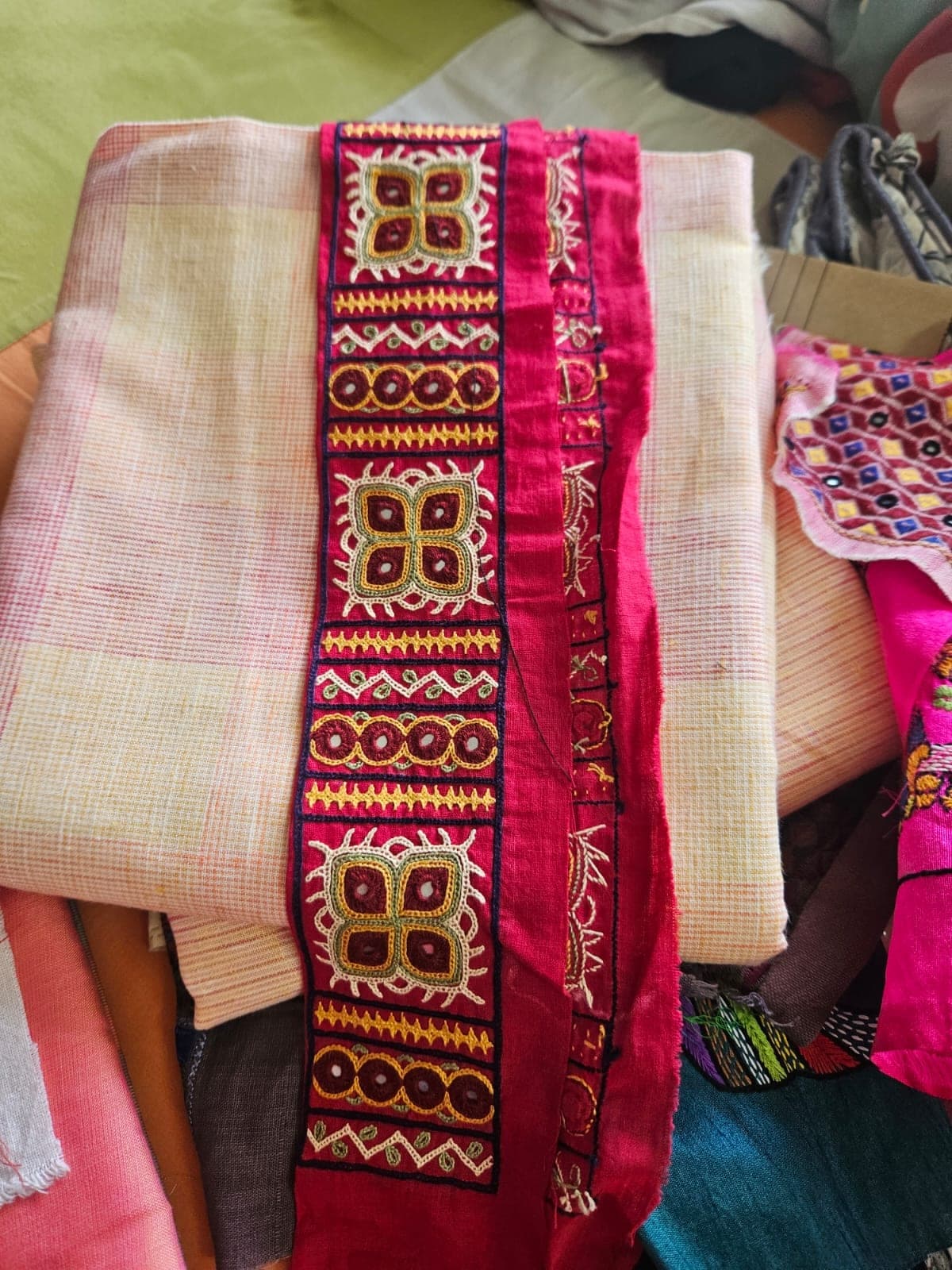 A red embroidered strip laid on pink checked fabric