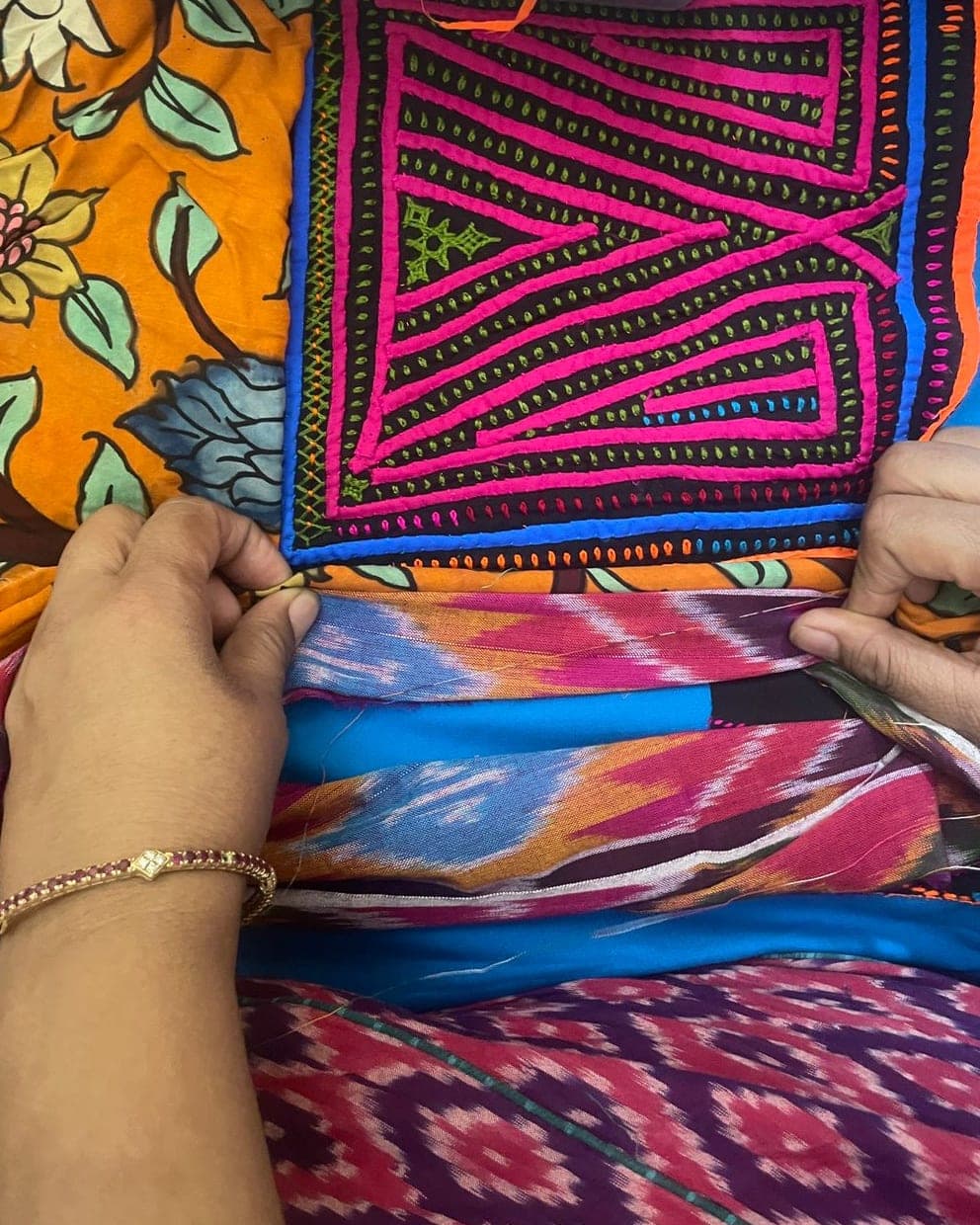 Hema’s hands pairing a pink and black patch with ikat and printed fabrics
